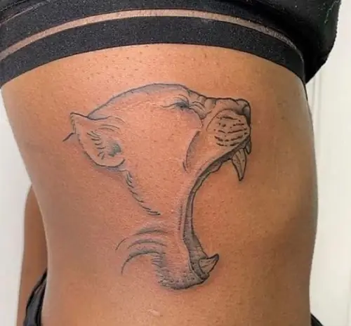 Roaring panther side profile — ribs tattoo